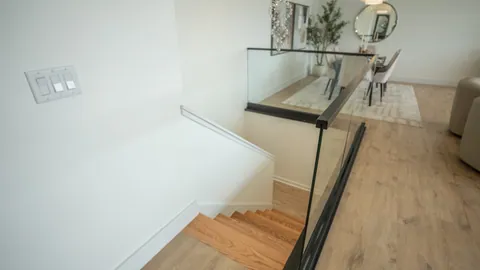 The oak stair and glass rail in a two level River Rock residence.